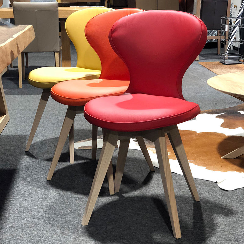 R1 leather dining chair with oak legs, shown in red orange and yellow options