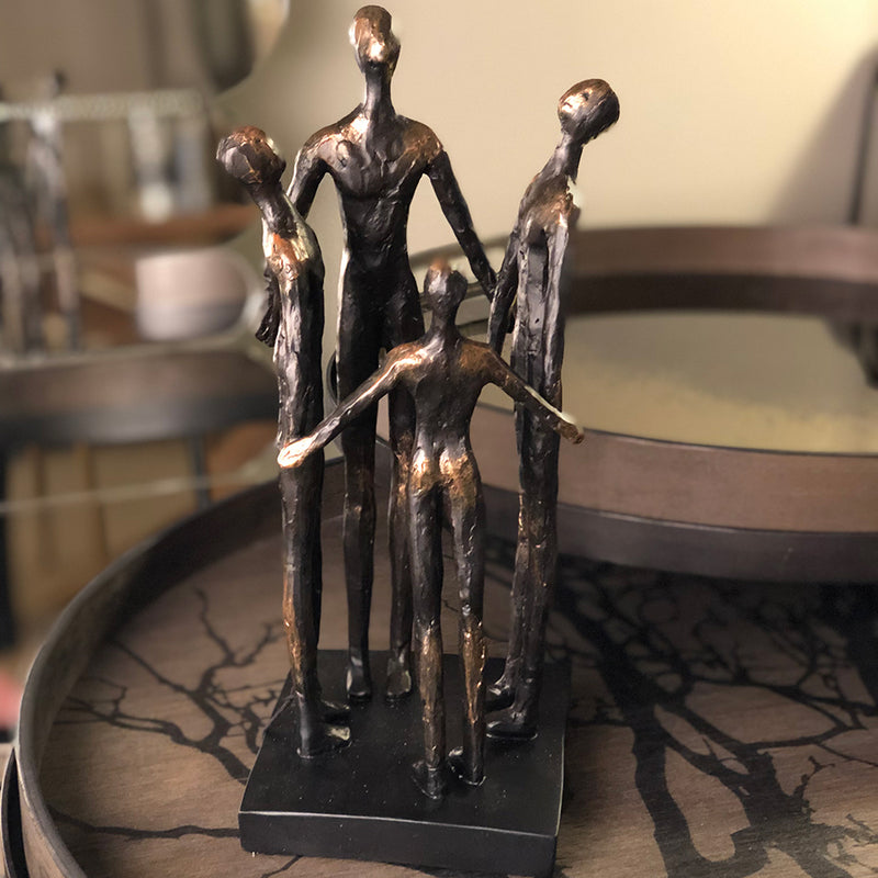 Foour people holding hands in a small circle, two adults, 2 children. rough finish in brown bronze colour