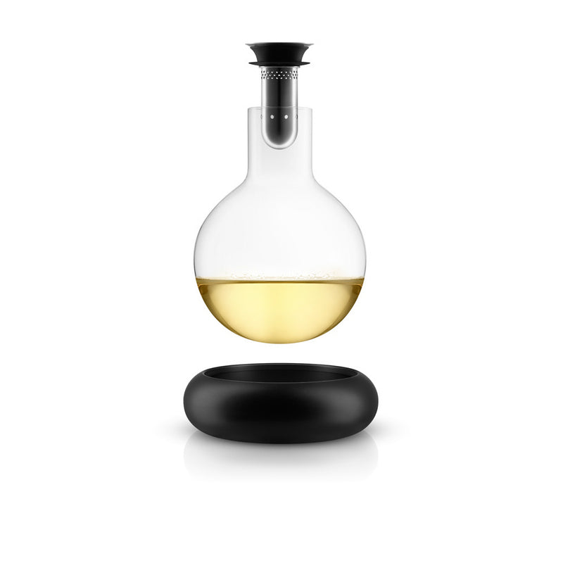 Cool decanter - , round clear glass container , lifted off of cool .black base.