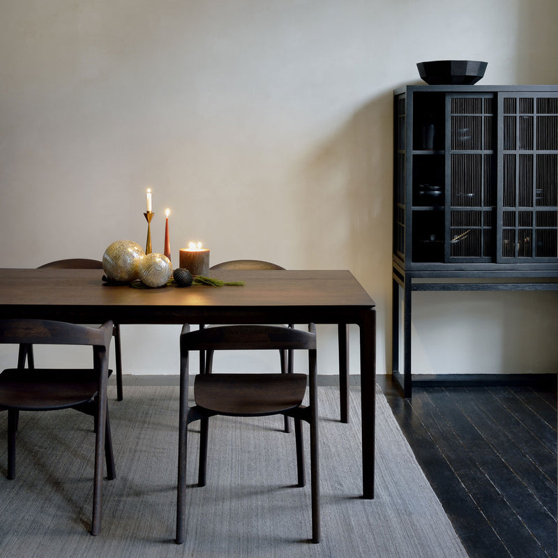 Dining room with a wooden oak table and chairs, candles, and decorative items.