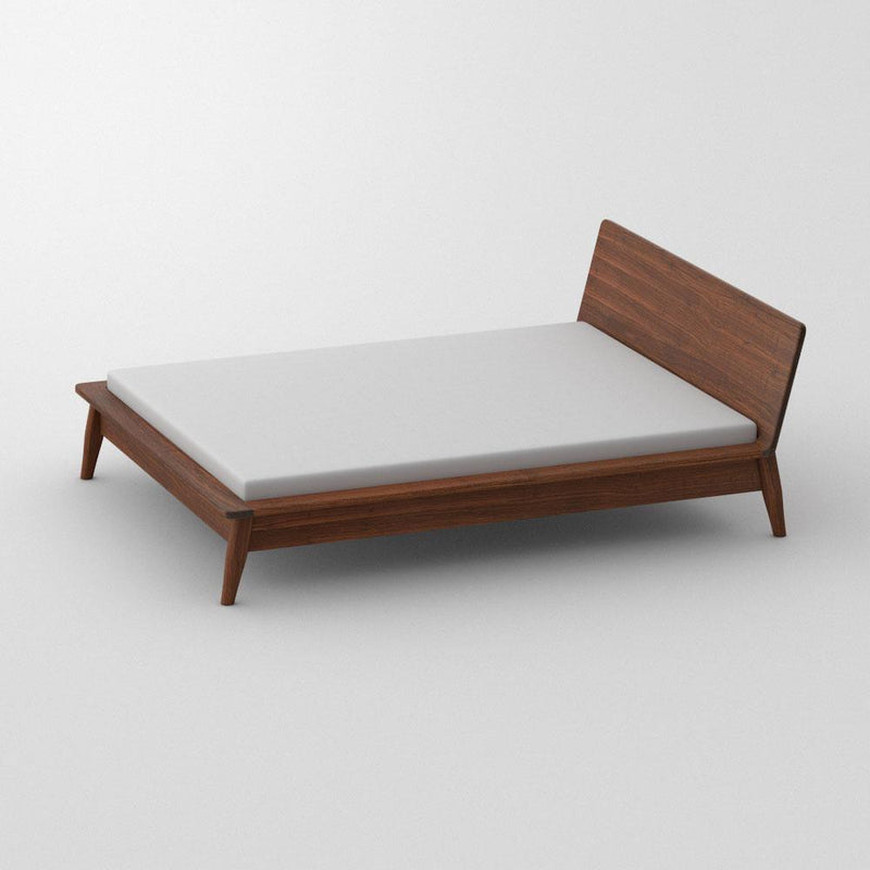 Side view of solid walnut double bed with white mattress