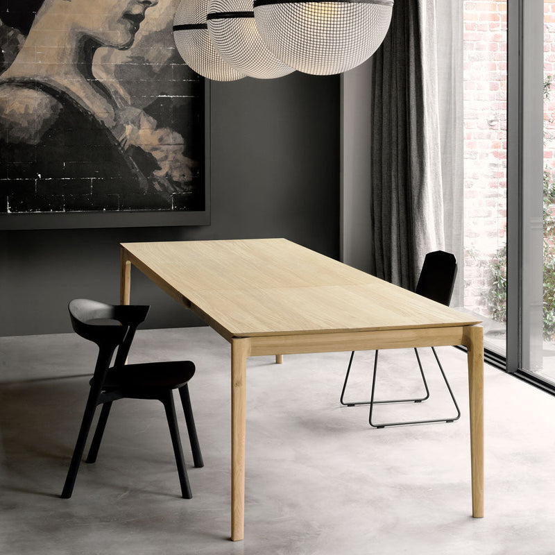 B1 table shown in contemporary home, with black chairs.side angle shows the smooth rounded leg.
