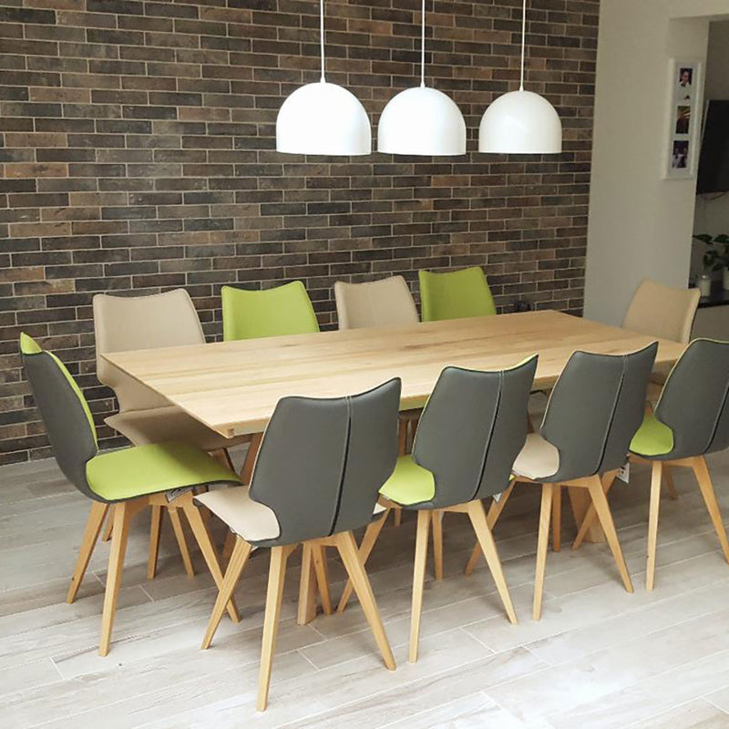set of c1 chairs arroung oak table in contemporary dining room. all grey backs, alternating lime and sand colour fronts.