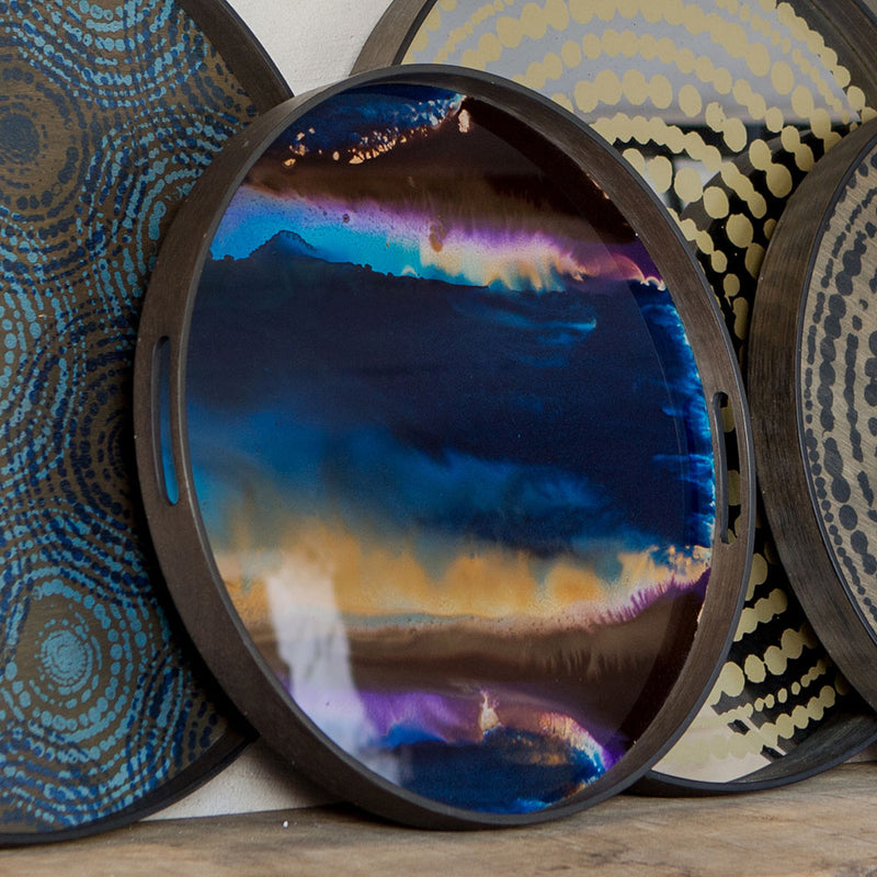 small round tray with glass bottom. under glass is painted purple blue gold and brown