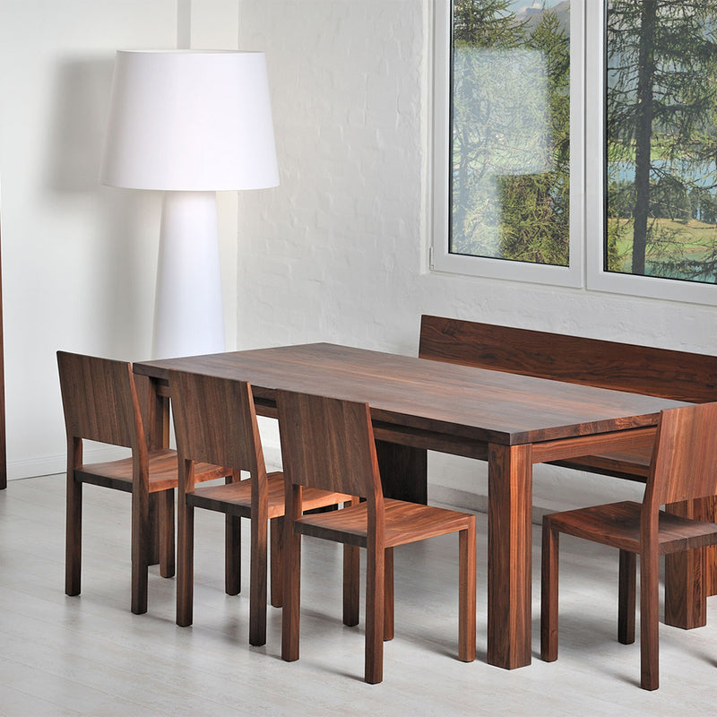 journeyman dining table in walnut,  shown in modern dining room with walnut chairs