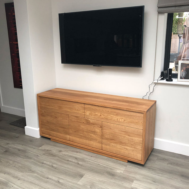 Linn sideboard with flat handle less front. two drawers over three doors- shown under tv on wall.