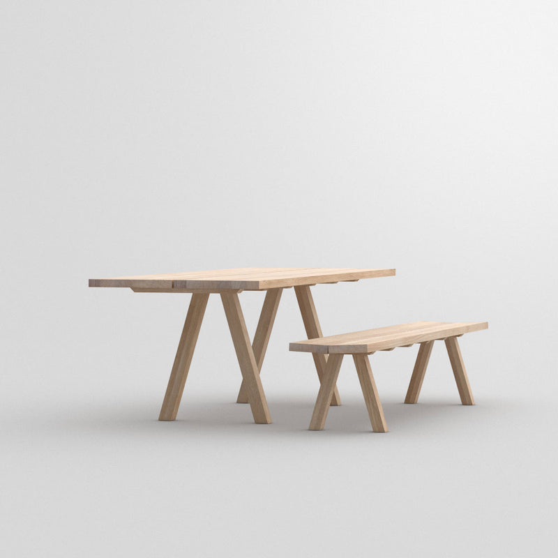 Facile dining table in oak with accompanying bench,front view of legs 
