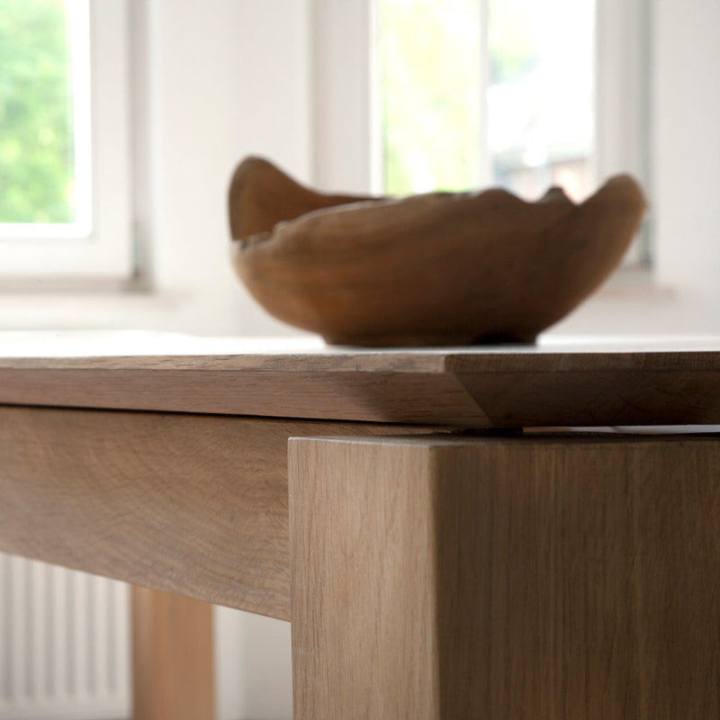 oak dining table showing the angle to the underside of the planar table top, with oak bowl