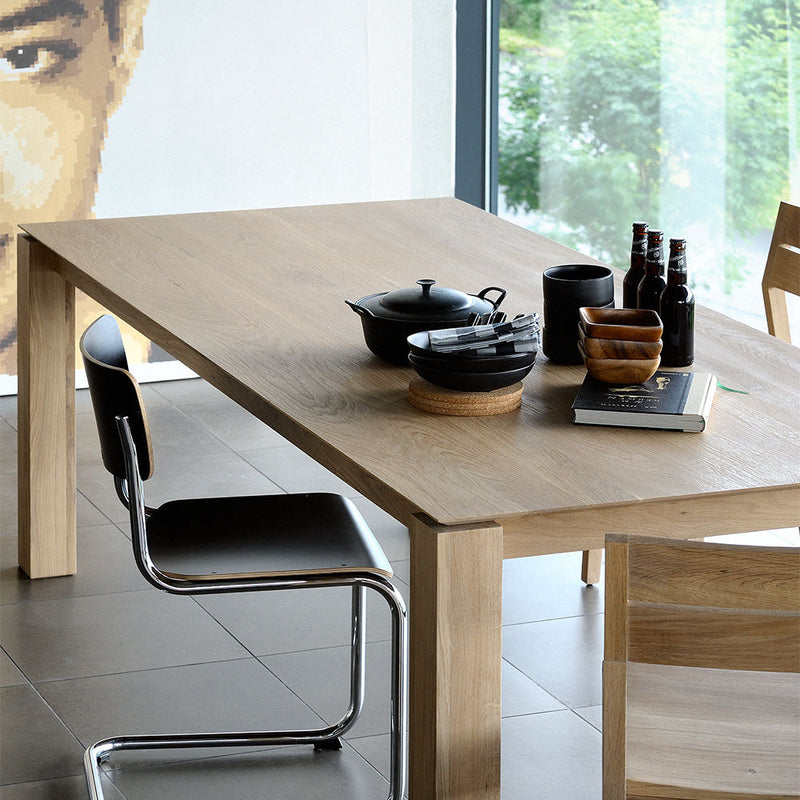 Oak planar fixed table styled with bottles and plates for entertaining friends