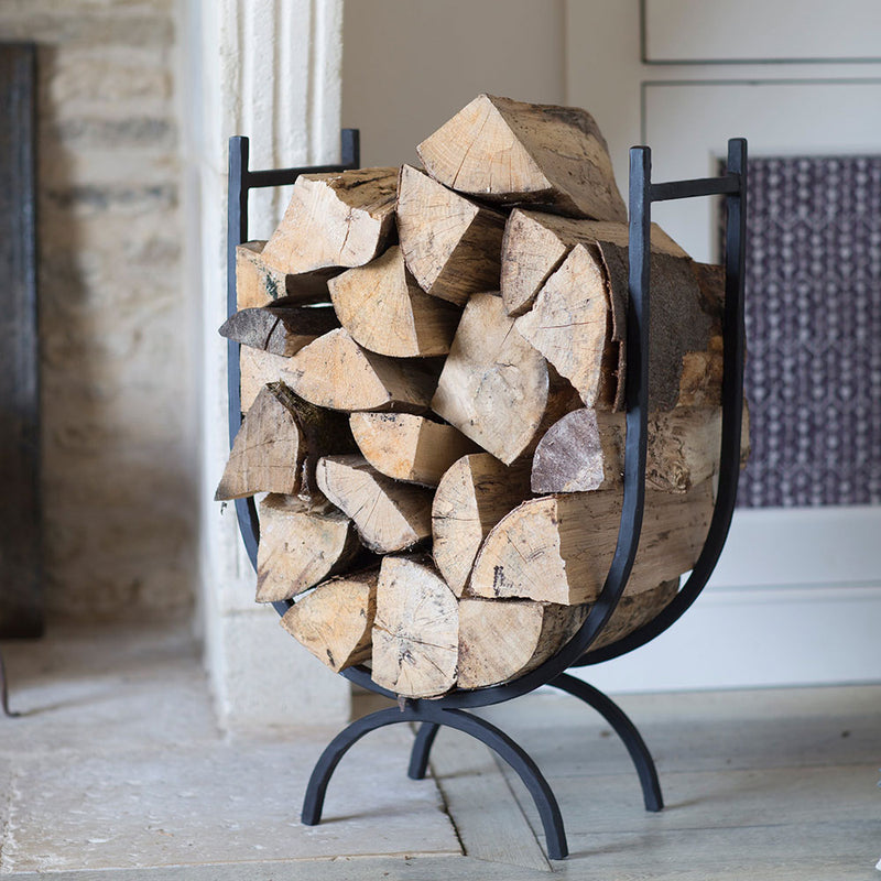 black wrought iron U shaped log stack shown with logs
