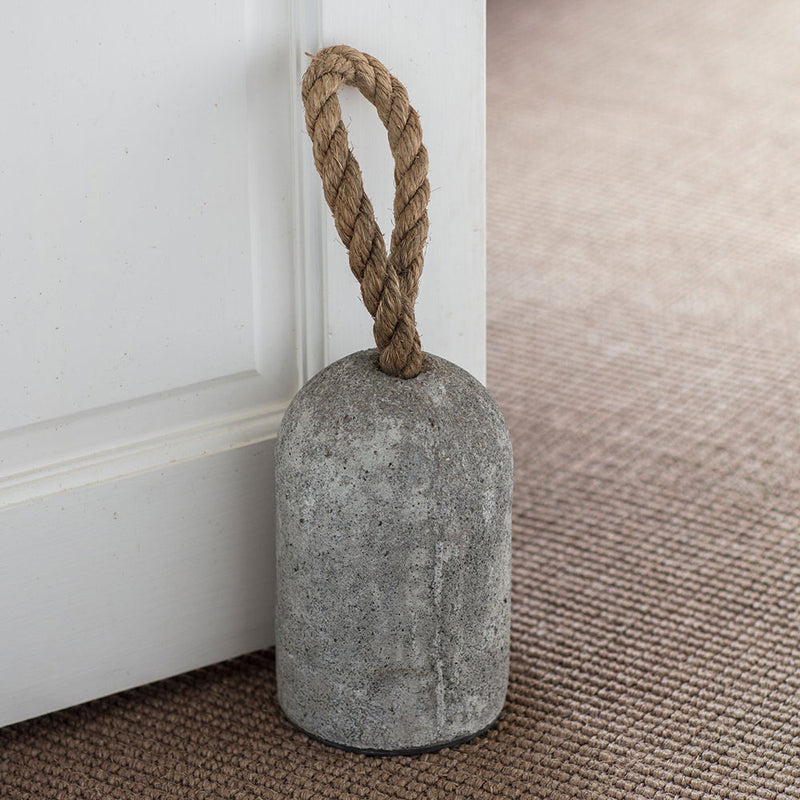 grey cement doorstop, bullet shaped, with a jute rope handle