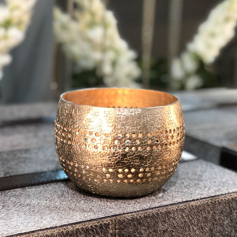 round bowl shaped votive holder with a golden finish. cut away holes for the light to show through.