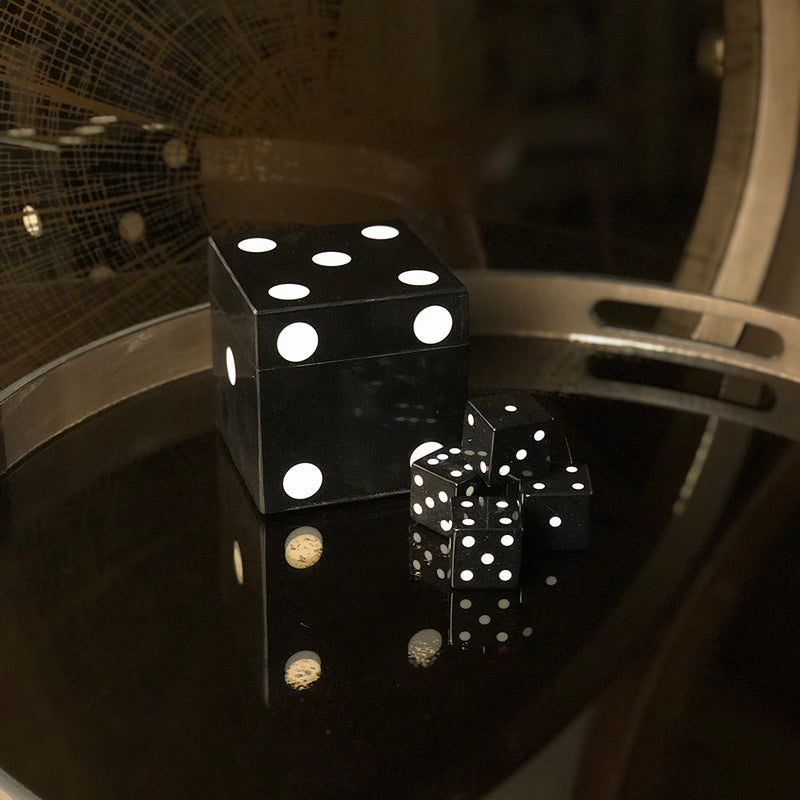 Large black dice on gold tray shown with 3 tiny dice 