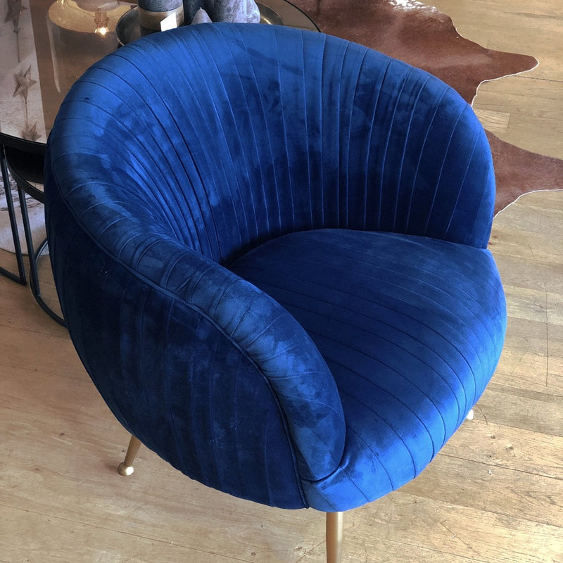cobalt blue tub chair covered front and back with pleated velvet. champagne gold legs.