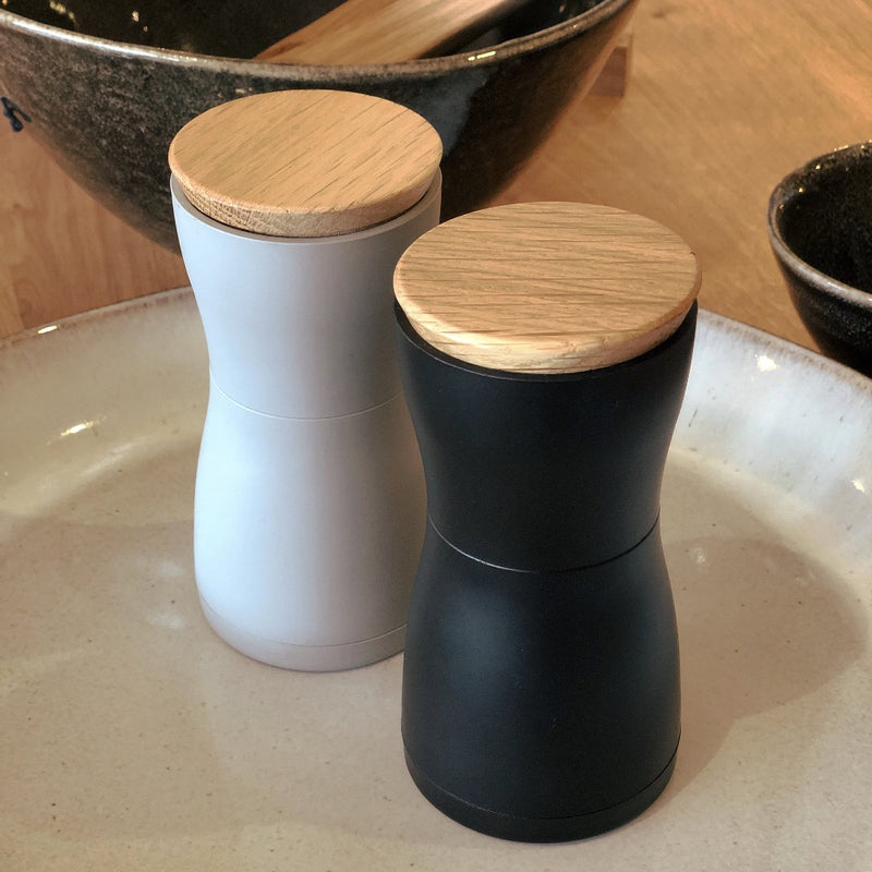 dark grey and light grey (pair) of salt and pepper grinders, with wood tops.