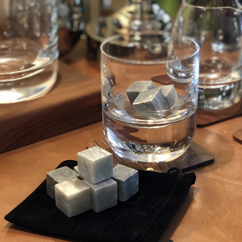 drinks stones, shown in a whisky glass, they are grey mineral cubes.