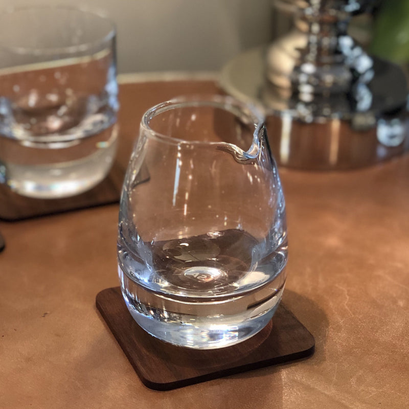 glass whiskey water jug on walnut coaster
