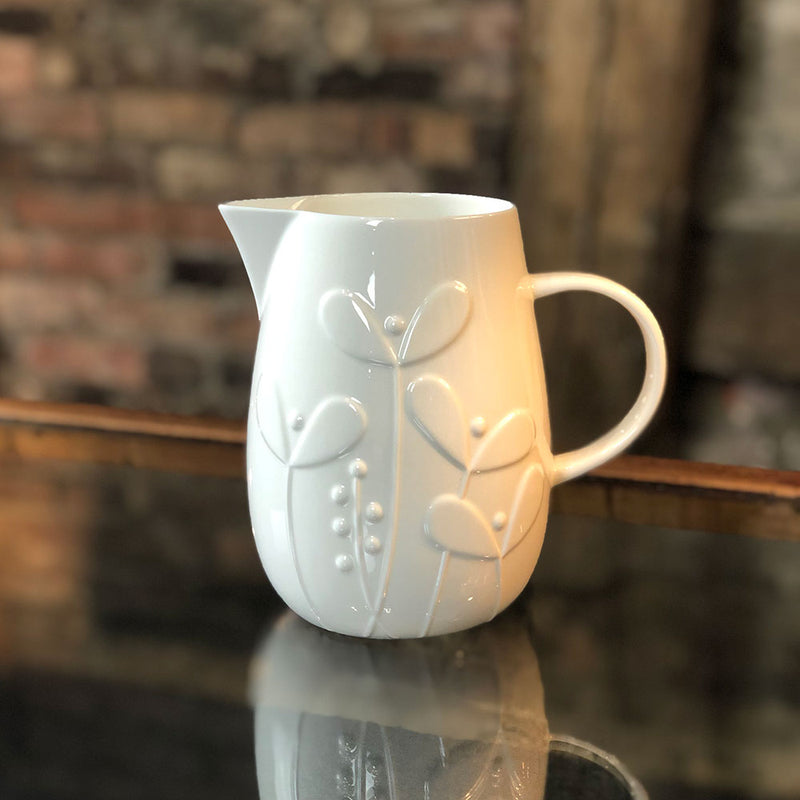 white bone china large jug with raised pattern of growing shoots and stems growing from the base
