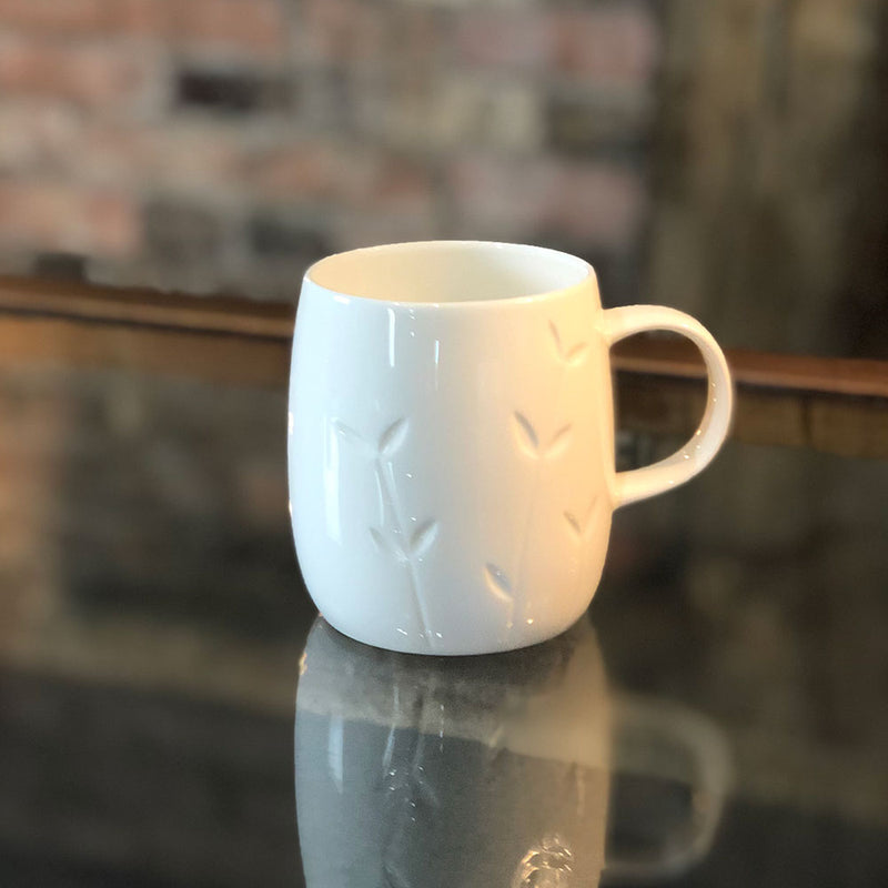 white bone china mug with indented design of growing leaves