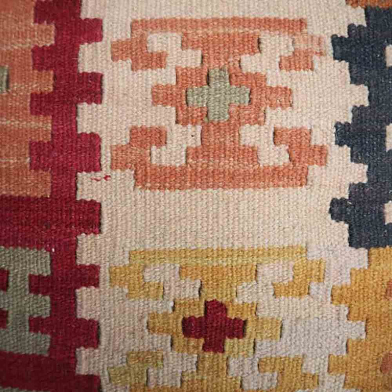 close up of woven kelim fabric seat- cream, red, navy, orange and pink pattern